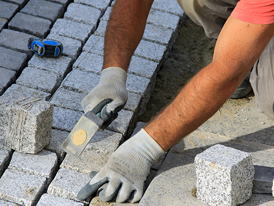 Une personne qui pose des dalles de beton