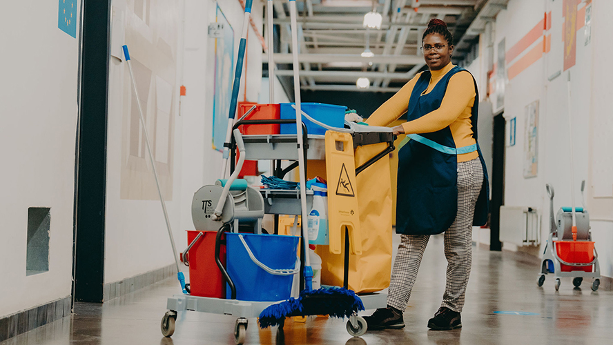 une dame avec un chariot de nettoyage