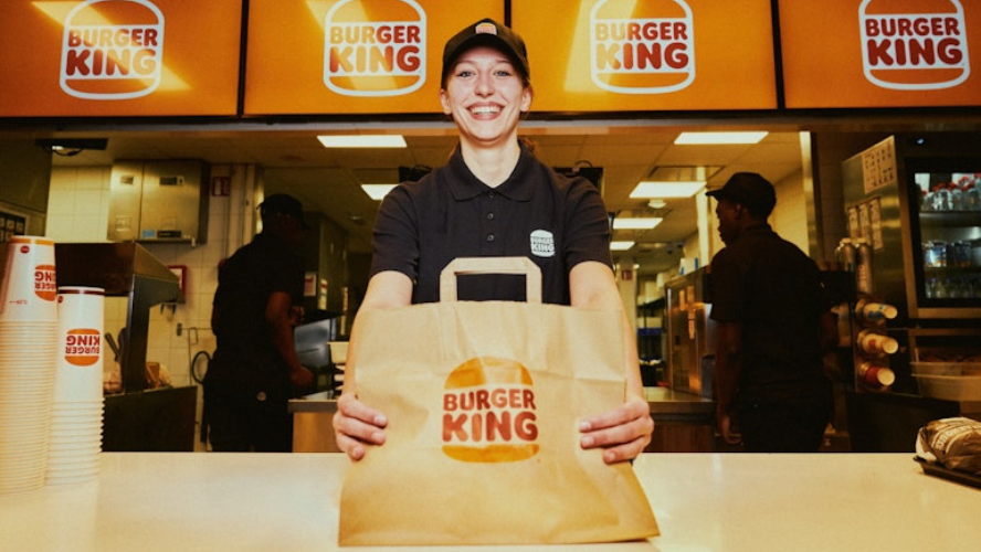 Photo d'une employée de Burger King servant un menu