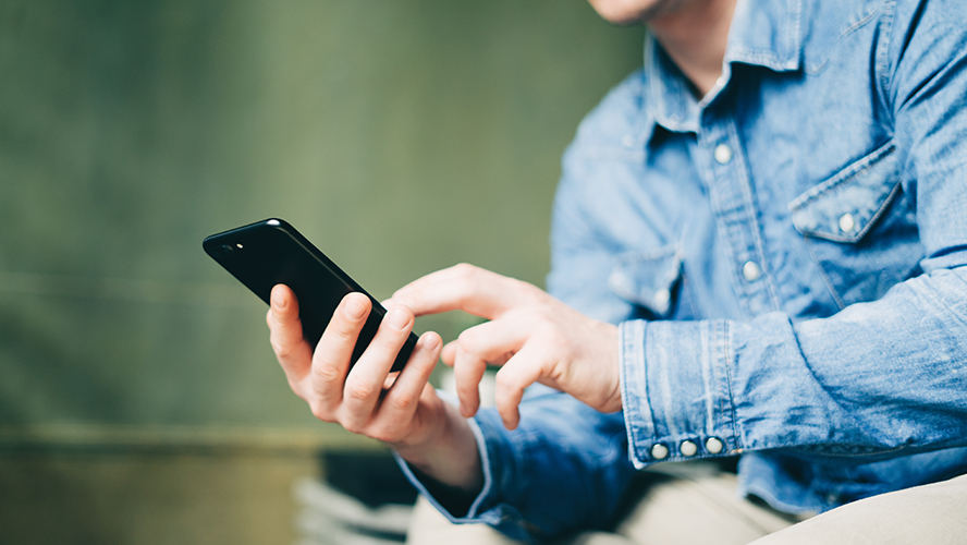 homme regarde son smartphone