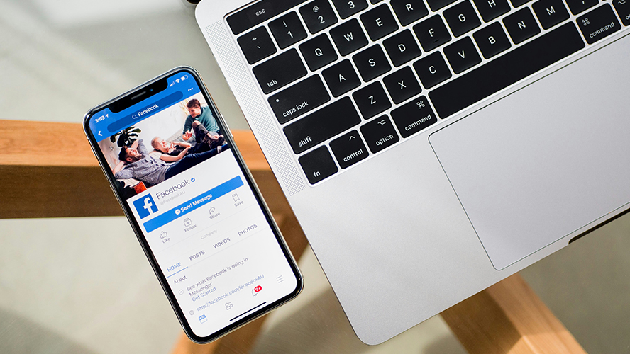 Ordinateur et smartphone affichant une page facebook