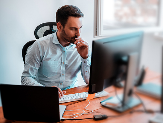 Manager assis à son bureau, travaillant sur son ordinateur