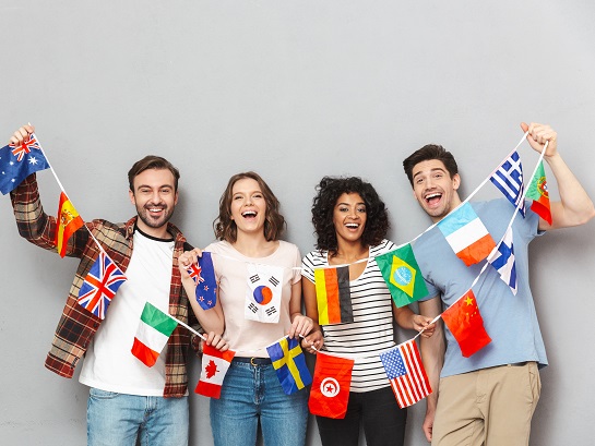 4 jeunes qui portent ensemble une farandole de petits drapeaux