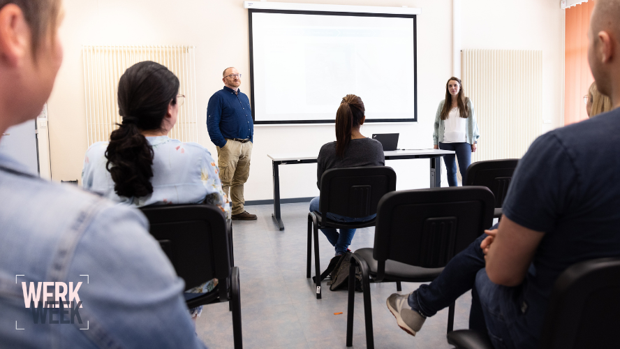 Image de 2 personnes qui font une présentation devant plusieurs personnes assises