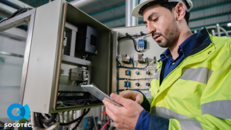 Un homme en tenue de travail inspecte un coffret électrique