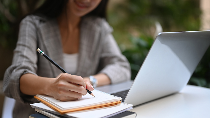 Femme prenant des notes + PC