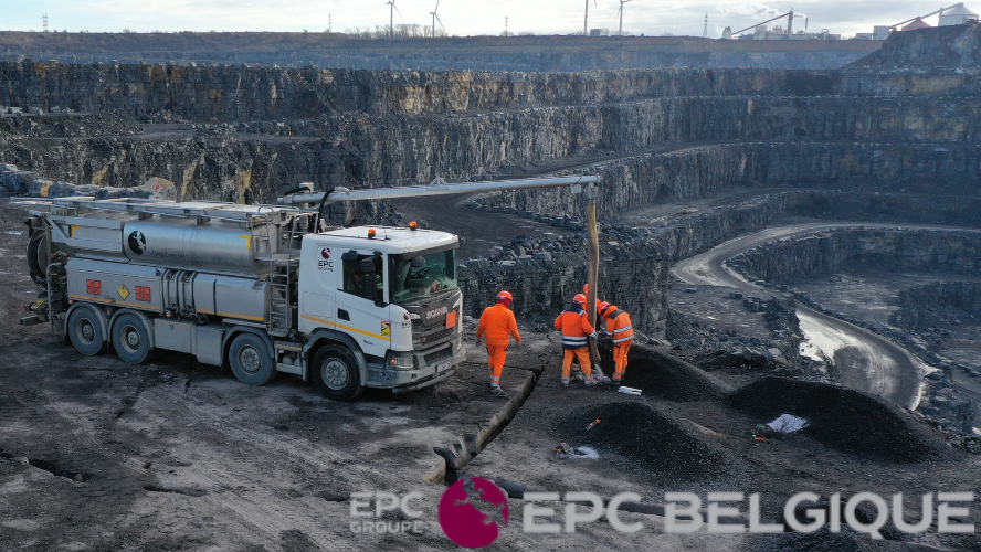 vue d'une mine avec des ouvriers autour d'un camion de forage